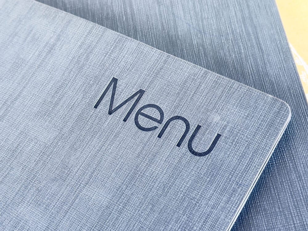 A slate grey book with the word "Menu" on it.