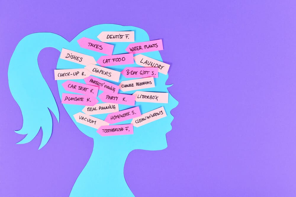 The silhouette of a woman's head filled with what she needs to do e.g. dentist, taxes, cat food, water plants, diapers, dishes.